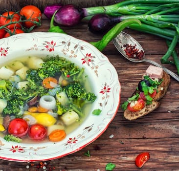 traditional soup of fresh vegetables in a deep dish on the background and vegetable sandwich.Photo tinted