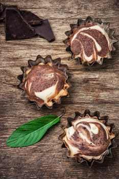 baked chocolate dessert in iron forms on wooden surface.Photo tinted