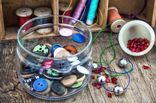 vase with buttons and tools for needlework beading and sewing in vintage style.Selective focus