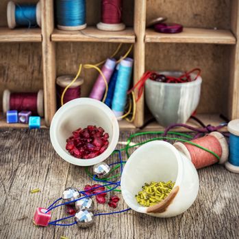 different tools for needlework beading and sewing in vintage style.Selective focus.Photo tinted