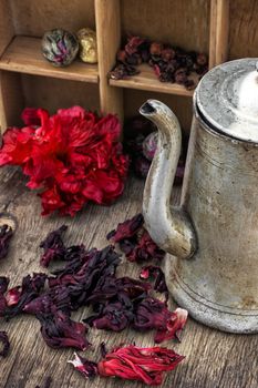 Hibiscus tea rose and welding on the background of the tea shelves in vintage style.Photo tinted.Selective focus