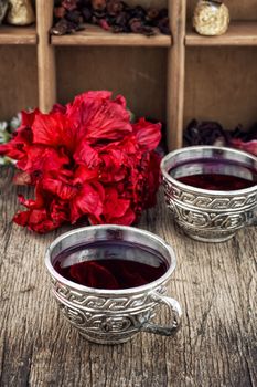 Hibiscus tea rose and welding on the background of the tea shelves in vintage style.Photo tinted