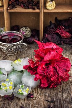 Hibiscus tea rose and welding on the background of the tea shelves in vintage style.Photo tinted.Selective focus