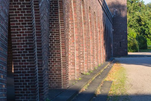 Old building with brick arches along a road.