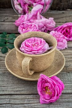 Cup with fresh fragrant herbal decoction of tea rose.The image is tinted.Selective focus