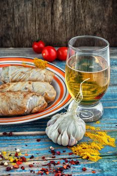 Turkey sausages roasted on a round plate on a wooden surface with glass of light beer.The image is tinted.Selective focus