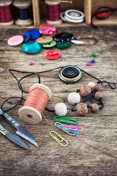 set of threads and buttons on wooden background.Selective focus