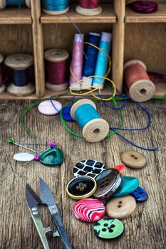 set of threads and buttons on wooden background.Selective focus
