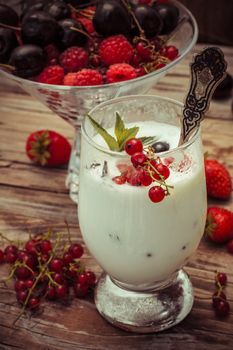 sweet dessert of ice cream per glass and fresh berries, cherries,currants,strawberries.Photo tinted.