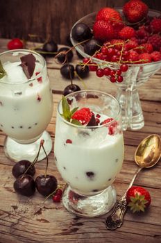 sweet dessert of ice cream per glass and fresh berries, cherries,currants,strawberries.Photo tinted.