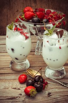 sweet dessert of ice cream per glass and fresh berries, cherries,currants,strawberries.Photo tinted.
