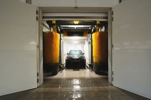station washing tunnel with white gate and car in it