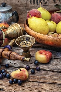 Details were worked hookah on the table amid fresh peaches.Photo tinted.