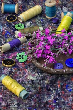 sewing thread and buttons on the background batting is decorated with blooming lavender.Photo tinted.Selective focus