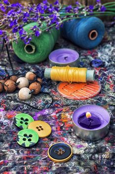 sewing thread and buttons on the background batting is decorated with blooming lavender.Photo tinted.