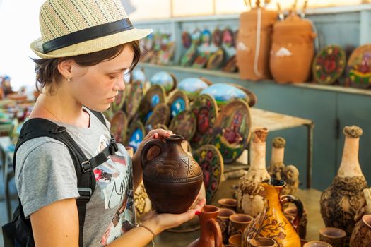 the young beautiful woman holds in hand a handwork jug on the Opening day in Armenia