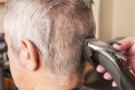 woman cuts hair with scissors, razor in  professional hairdressing salon