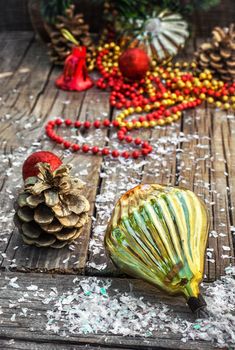 Christmas ornaments and pine cones on wooden background.Photo tinted.Superimposed texture.