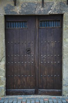 Old rustic wooden door painted in dark brown