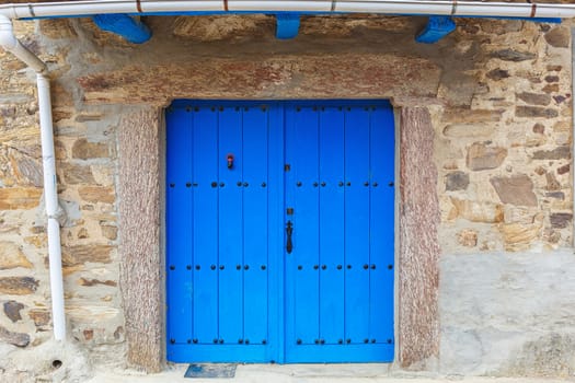 Old rustic wooden door painted in blue 