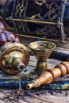 Old smoking  hookah on wooden surface.Photo tinted