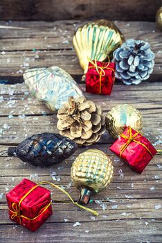 Christmas ornaments and pine cones on wooden background.Photo tinted.Superimposed texture.