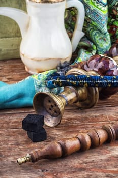 Old smoking  hookah on wooden surface.Photo tinted