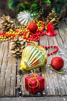 Christmas ornaments and pine cones on wooden background.Photo tinted.