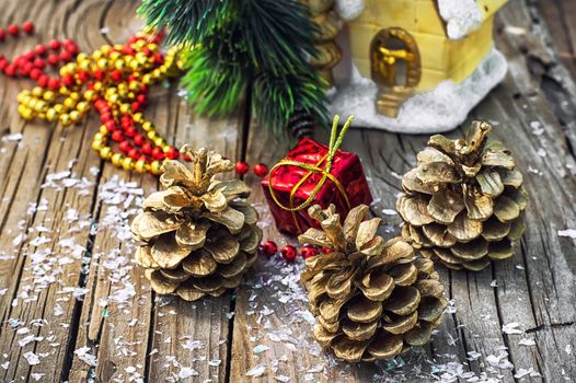 Christmas ornaments and pine cones on wooden background.Photo tinted.