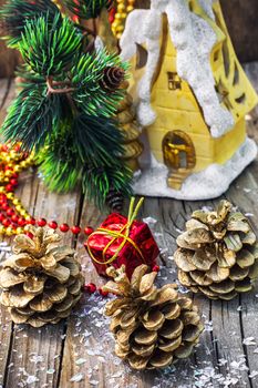 Christmas ornaments and pine cones on wooden background.Photo tinted.