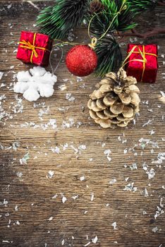 Traditional Christmas decorations of balls and cones on wooden table in vintage style.