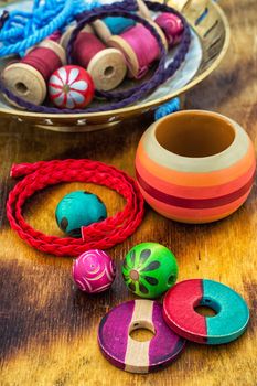 Wooden beads and accessories for needlework on bright orange background