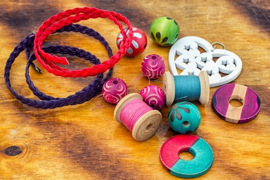 Wooden beads and accessories for needlework on bright orange background