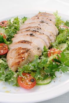 Cut into slices of grilled chicken breast with vegetable garnish