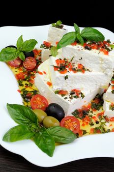 Pieces of feta   with basil and olives, cherry tomatoes