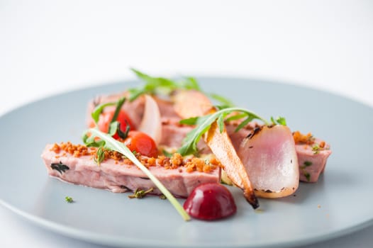 Roasted duck breast in modern cuisine style with vegetable and herbs