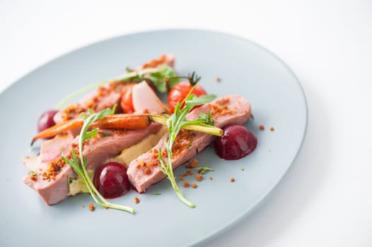 Roasted duck breast in modern cuisine style with vegetable and herbs