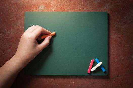 Woman left hand writing on small black board in green color with blank space for text or message with low key scene