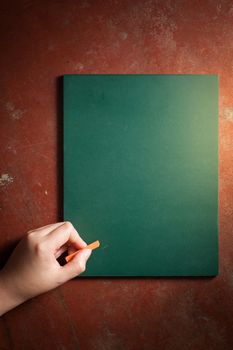 Woman left hand writing on small black board in green color with blank space for text or message with low key scene