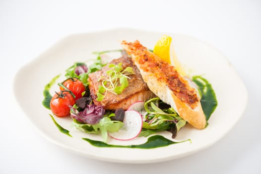 Modern style clean food, grilled salmon with toast and salad dressed with green sauce