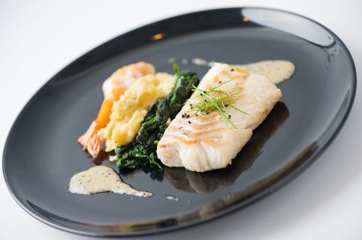 Cod fish steak with shrimp, mesh potato, and vegetable, modern style food