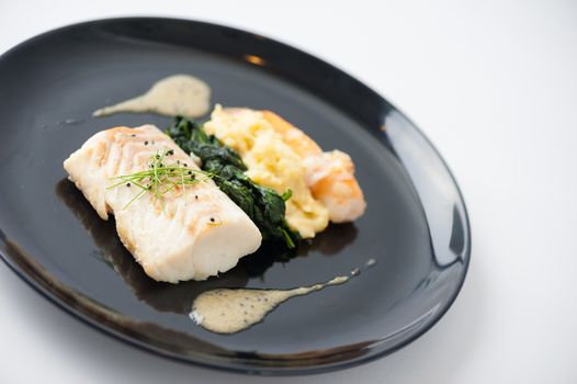 Cod fish steak with shrimp, mesh potato, and vegetable, modern style food