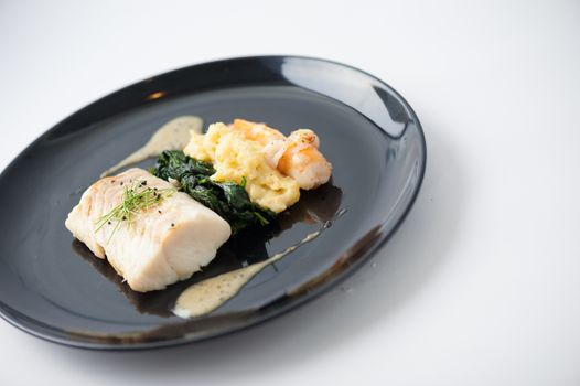 Cod fish steak with shrimp, mesh potato, and vegetable, modern style food