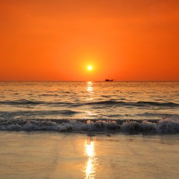 Sunset over sea and silhouette of traditional longtail boat in Thailand