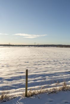 Winter Field in Umeå, Sweden with a mostly clear blue sky.