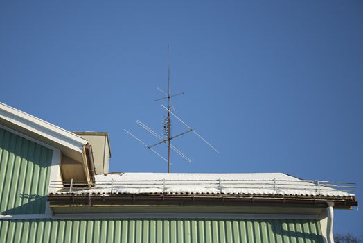 TV Antenna on Snow Covered Roof.