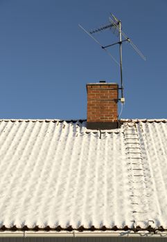 Snow Covered Roof with Chimney and TV Antenna.
