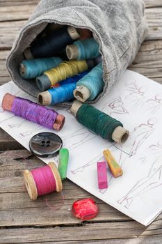 bag sewing thread and a sketch on a wooden table