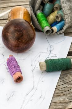 bag sewing thread and a sketch on a wooden table