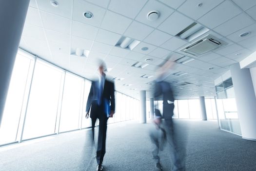 Abstract blurry portrait of walking businessman in office